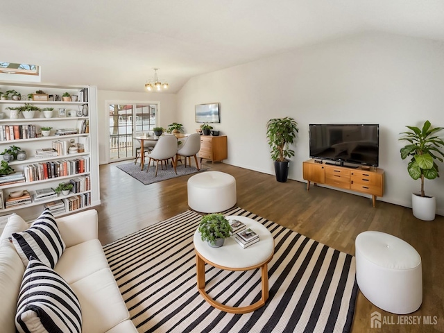 living room with a chandelier, lofted ceiling, and wood finished floors