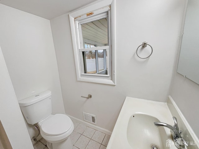 bathroom with baseboards, visible vents, a sink, tile patterned floors, and toilet