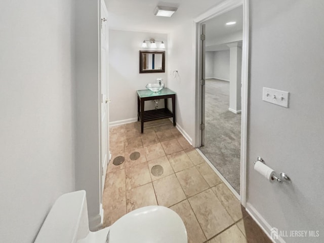 bathroom with tile patterned floors, toilet, vanity, and baseboards