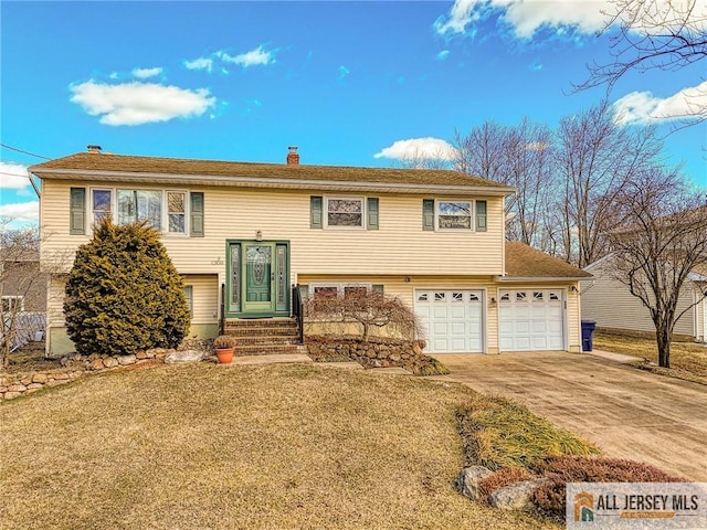 raised ranch featuring entry steps, a chimney, concrete driveway, and a front yard