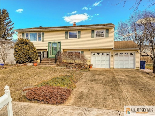 bi-level home with a front yard, driveway, and a chimney