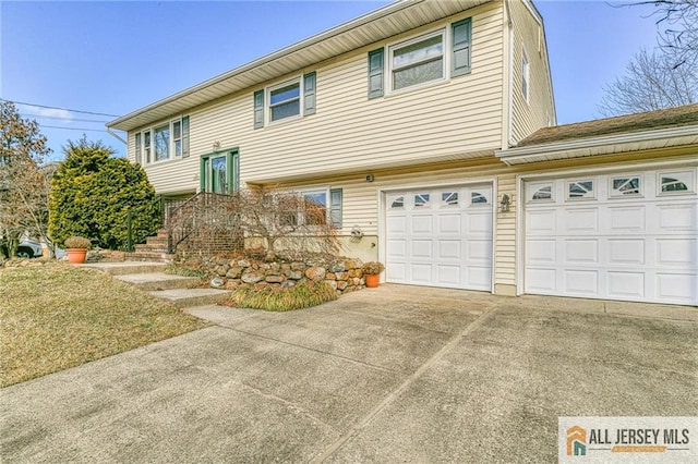 bi-level home with a garage, driveway, and a front yard