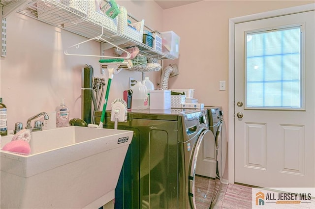 laundry room with laundry area, a sink, and separate washer and dryer