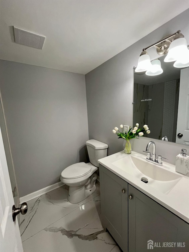 bathroom featuring marble finish floor, visible vents, toilet, vanity, and baseboards