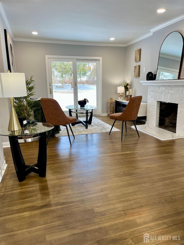 living area with a fireplace, recessed lighting, ornamental molding, wood finished floors, and baseboards