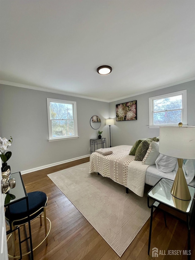 bedroom featuring multiple windows, baseboards, dark wood-style flooring, and crown molding