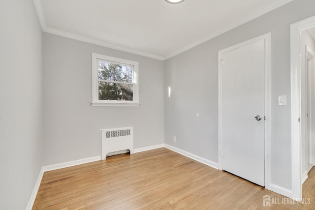 unfurnished room featuring light wood-type flooring, radiator heating unit, and ornamental molding