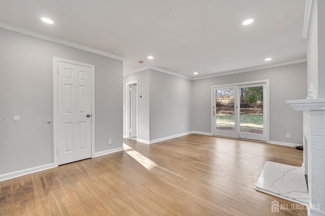 unfurnished living room featuring crown molding, light hardwood / wood-style flooring, and a brick fireplace