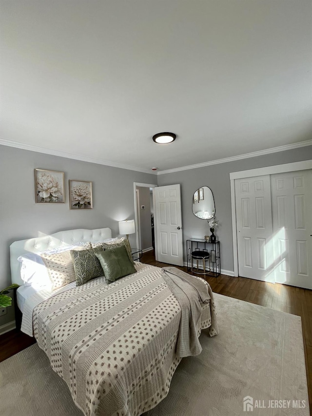 bedroom with crown molding, baseboards, and wood finished floors