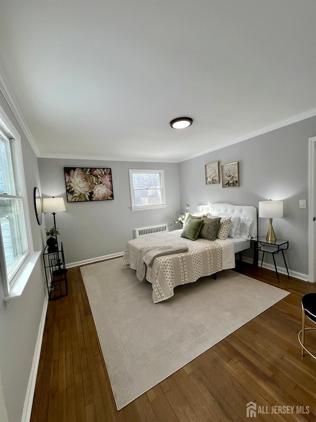 bedroom featuring dark wood-style flooring, crown molding, and baseboards