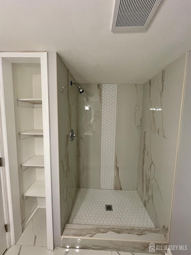 full bathroom featuring marble finish floor, a stall shower, and visible vents