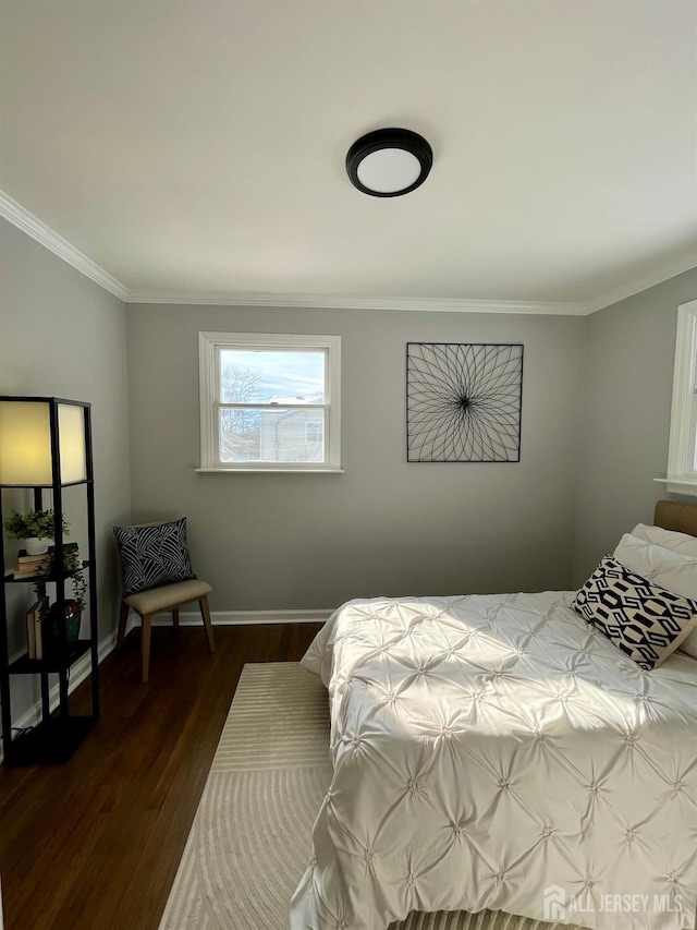 bedroom with ornamental molding, dark wood finished floors, and baseboards