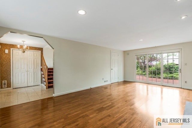 10 Lauri Ln, Middlesex, NJ 08846 - unfurnished living room with a chandelier, arched walkways, wood finished floors, baseboards, and recessed lighting