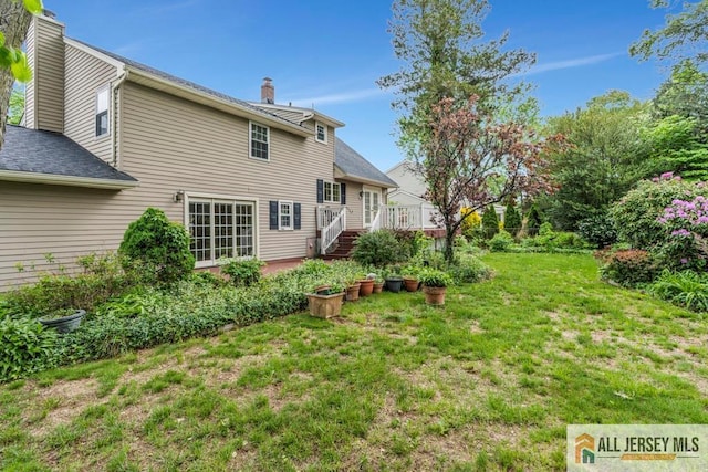 10 Lauri Ln, Middlesex, NJ 08846 - back of house featuring a chimney, a lawn, a deck, and roof with shingles