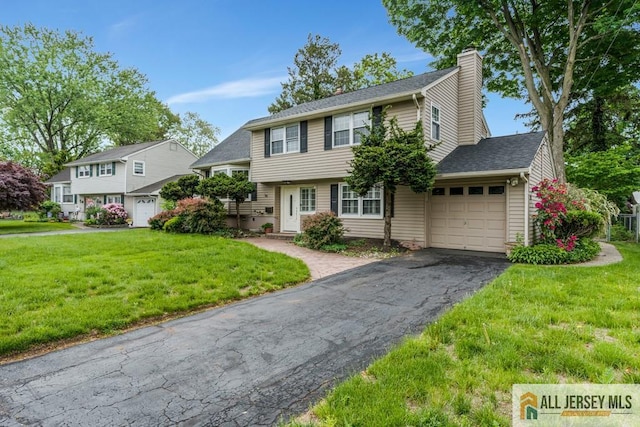 10 Lauri Ln, Middlesex, NJ 08846 - view of front of home featuring a garage, driveway, a chimney, and a front lawn