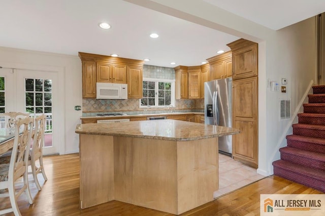 10 Lauri Ln, Middlesex, NJ 08846 - kitchen with stainless steel fridge with ice dispenser, white microwave, light stone countertops, light wood finished floors, and a kitchen island