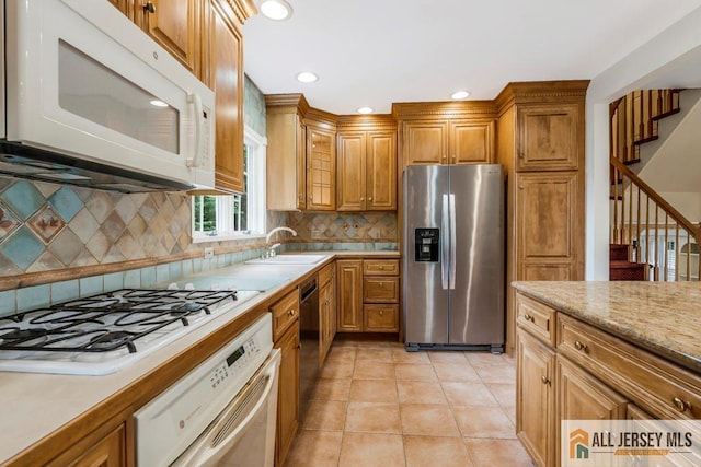 10 Lauri Ln, Middlesex, NJ 08846 - kitchen with white appliances, light countertops, brown cabinets, a sink, and recessed lighting