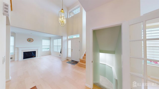 53 Kirschman Dr, Old Bridge, NJ 07747 - entrance foyer with a high ceiling, a chandelier, wood finished floors, a fireplace with flush hearth, and stairs