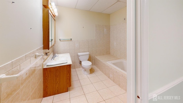 53 Kirschman Dr, Old Bridge, NJ 07747 - bathroom featuring vanity, tiled tub, tile patterned flooring, tile walls, and a paneled ceiling