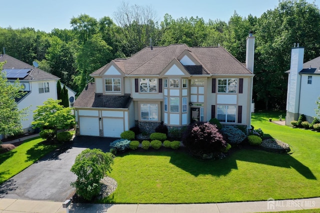 53 Kirschman Dr, Old Bridge, NJ 07747 - view of front of house with asphalt driveway, a garage, a front lawn, and a chimney