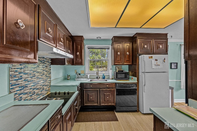 kitchen with light hardwood / wood-style flooring, sink, black appliances, dark brown cabinets, and decorative backsplash