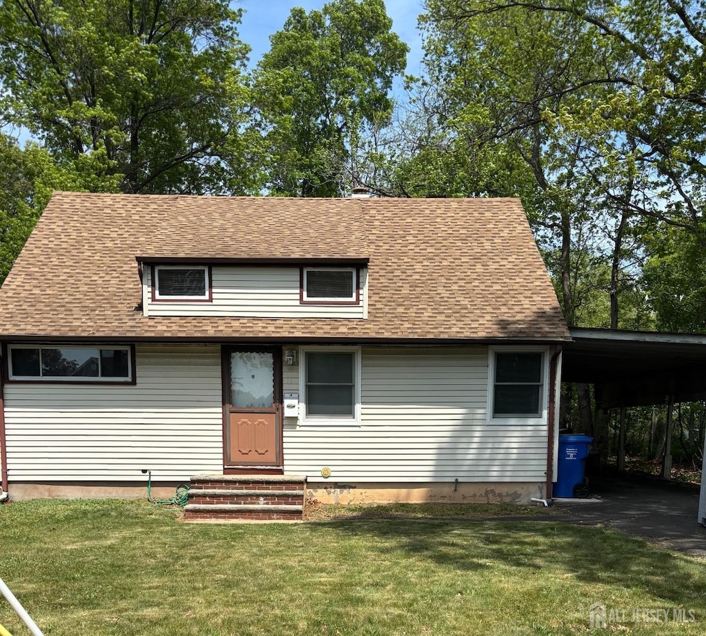 view of front of home featuring a front yard, roof with shingles, and an attached carport