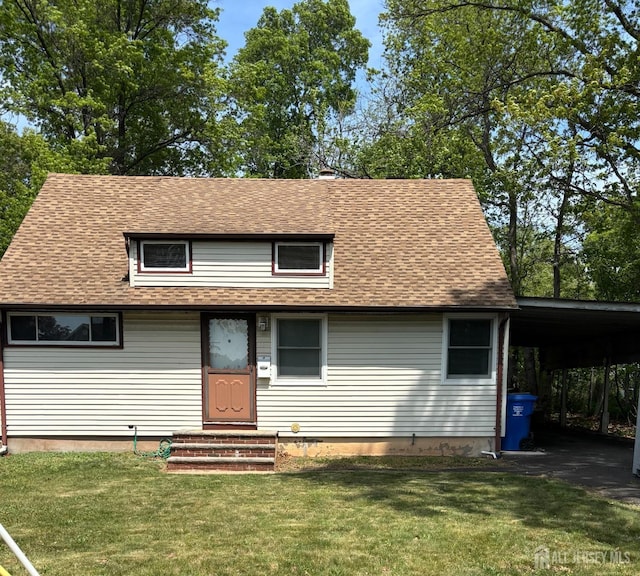 view of front of home featuring a front yard, roof with shingles, and an attached carport