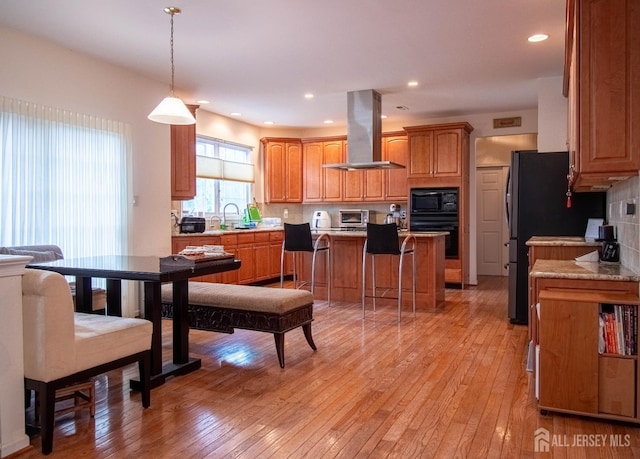 1 Saddle Ct, Monroe, NJ 08831 - kitchen with island range hood, black appliances, tasteful backsplash, light wood-type flooring, and recessed lighting