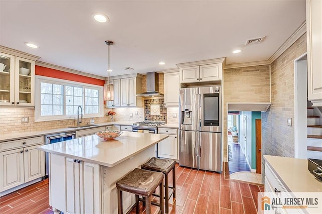 6 Mockingbird Rd, Edison, NJ 08820 - kitchen featuring appliances with stainless steel finishes, wall chimney exhaust hood, a sink, light countertops, and crown molding