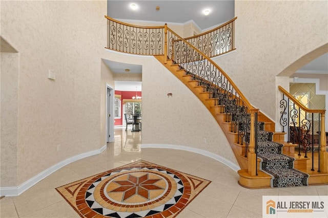 482 Spotswood Gravel Hill Rd, Monroe, NJ 08831 - stairs with tile patterned flooring, a high ceiling, crown molding, arched walkways, and baseboards