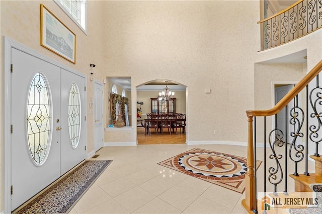 482 Spotswood Gravel Hill Rd, Monroe, NJ 08831 - foyer entrance featuring a high ceiling, arched walkways, a chandelier, stairs, and tile patterned floors