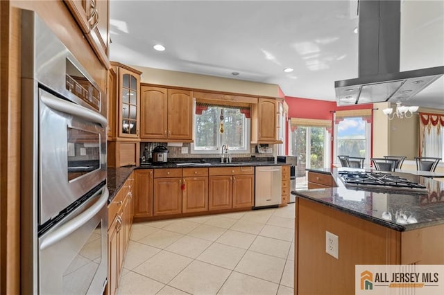 482 Spotswood Gravel Hill Rd, Monroe, NJ 08831 - kitchen with island exhaust hood, appliances with stainless steel finishes, light tile patterned floors, glass insert cabinets, and dark stone counters