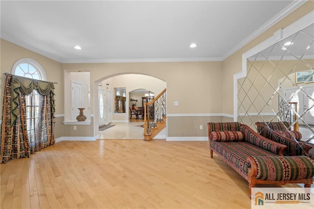 482 Spotswood Gravel Hill Rd, Monroe, NJ 08831 - living area with arched walkways, wood finished floors, stairs, a wainscoted wall, and crown molding