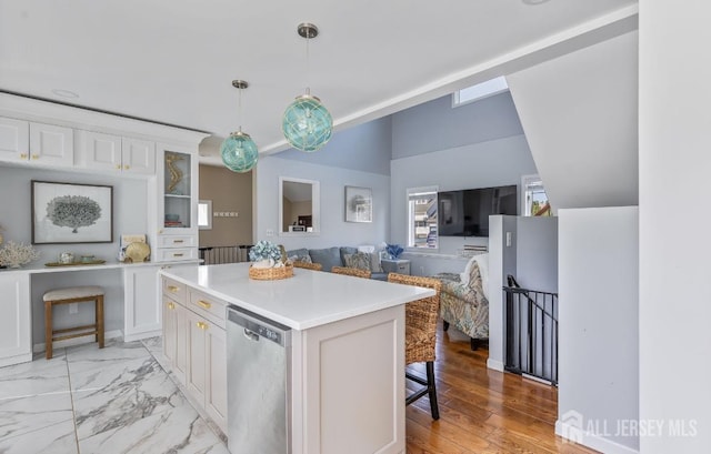 kitchen with white cabinets, dishwasher, light countertops, a kitchen breakfast bar, and a kitchen island