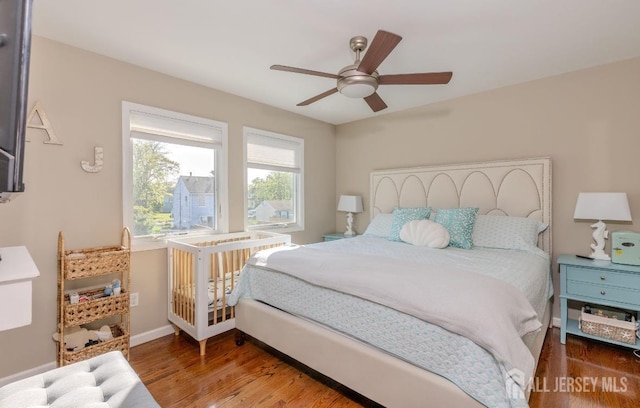bedroom featuring baseboards, a ceiling fan, and wood finished floors