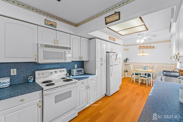 kitchen featuring white cabinets, ceiling fan, white appliances, and sink