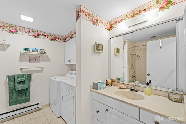 bathroom with a baseboard radiator, independent washer and dryer, tile patterned floors, tiled shower, and vanity