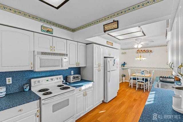 kitchen with white cabinetry, sink, ceiling fan, white appliances, and light wood-type flooring