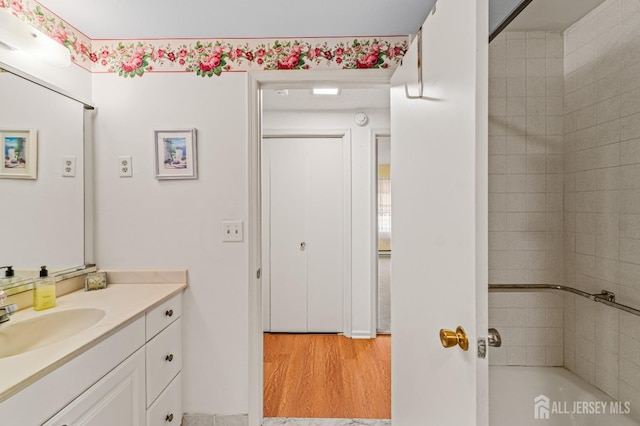 bathroom featuring hardwood / wood-style floors, vanity, and a bathing tub