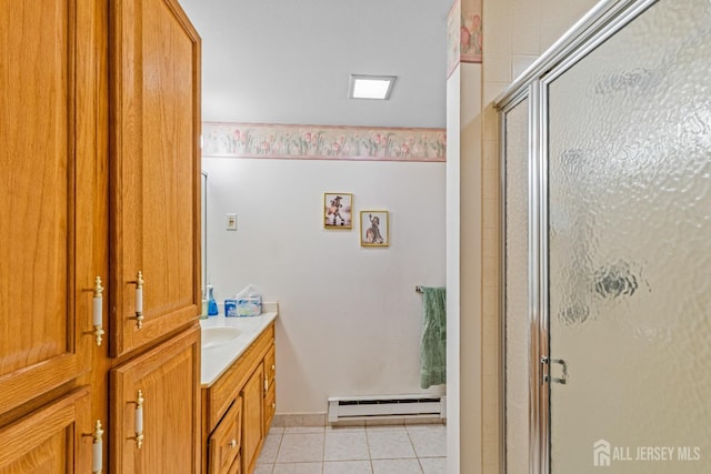 bathroom featuring tile patterned flooring, vanity, a shower with door, and baseboard heating