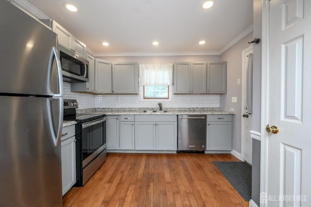 439 Old Main St, Franklin, NJ 08802 - kitchen with stainless steel appliances, gray cabinets, ornamental molding, backsplash, and light wood-style flooring