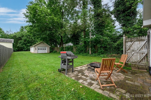 439 Old Main St, Franklin, NJ 08802 - fenced backyard featuring a fire pit, a patio, a gate, an outbuilding, and a detached garage