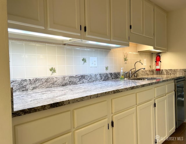 4424 Sayre Dr, Plainsboro, NJ 08540 - kitchen featuring a sink, decorative backsplash, beverage cooler, and light stone counters