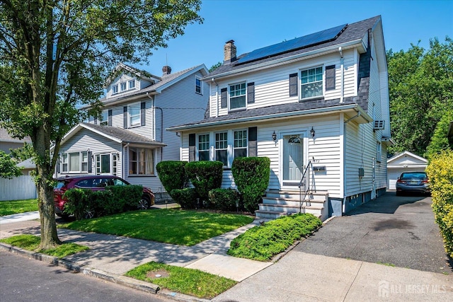 1072 Salem Ave, Hillside, NJ 07205 - view of front of property with entry steps, an outdoor structure, roof mounted solar panels, a chimney, and a front lawn