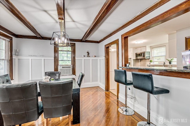 1072 Salem Ave, Hillside, NJ 07205 - dining room featuring a decorative wall, light wood-style flooring, cooling unit, healthy amount of natural light, and a chandelier