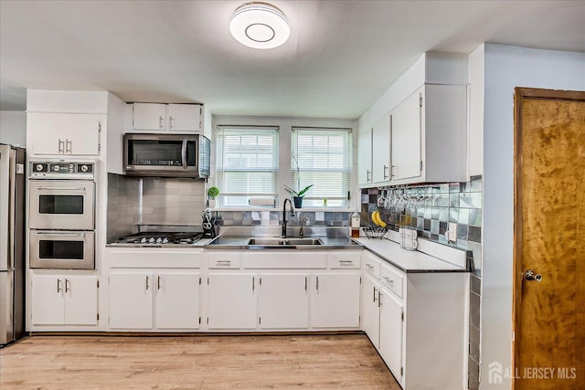 1072 Salem Ave, Hillside, NJ 07205 - kitchen featuring stainless steel appliances, white cabinets, tasteful backsplash, and light wood finished floors