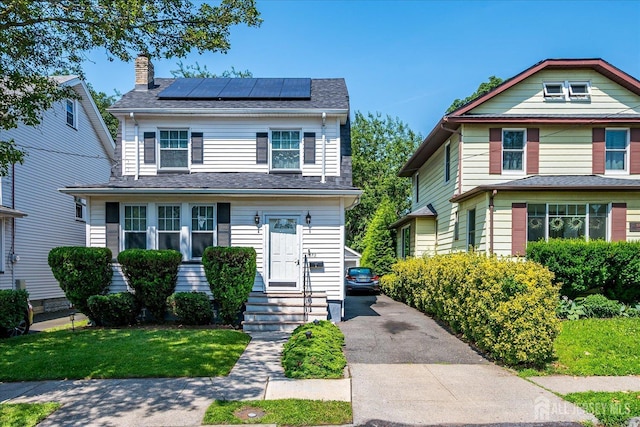 1072 Salem Ave, Hillside, NJ 07205 - view of front of property with roof mounted solar panels, a chimney, and driveway