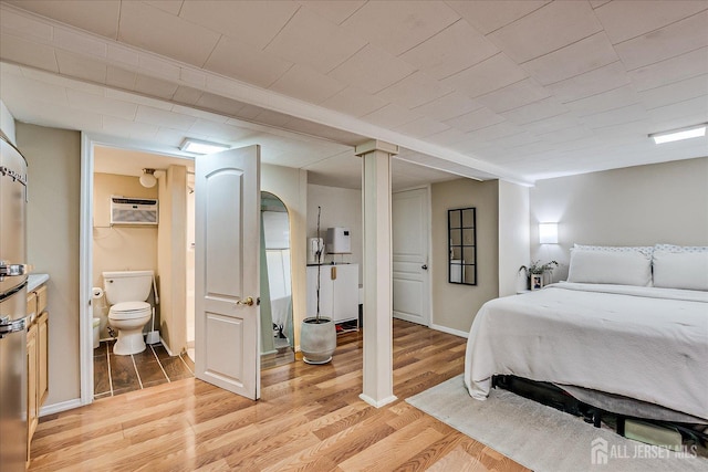1072 Salem Ave, Hillside, NJ 07205 - bedroom featuring a wall mounted air conditioner, light wood-style floors, and connected bathroom