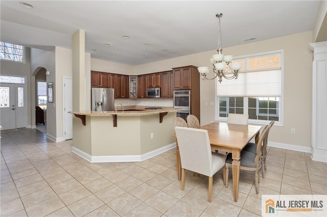 tiled dining area with sink, plenty of natural light, and a chandelier