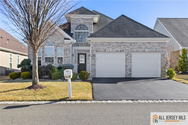 view of front of property featuring brick siding, a shingled roof, an attached garage, a front yard, and driveway